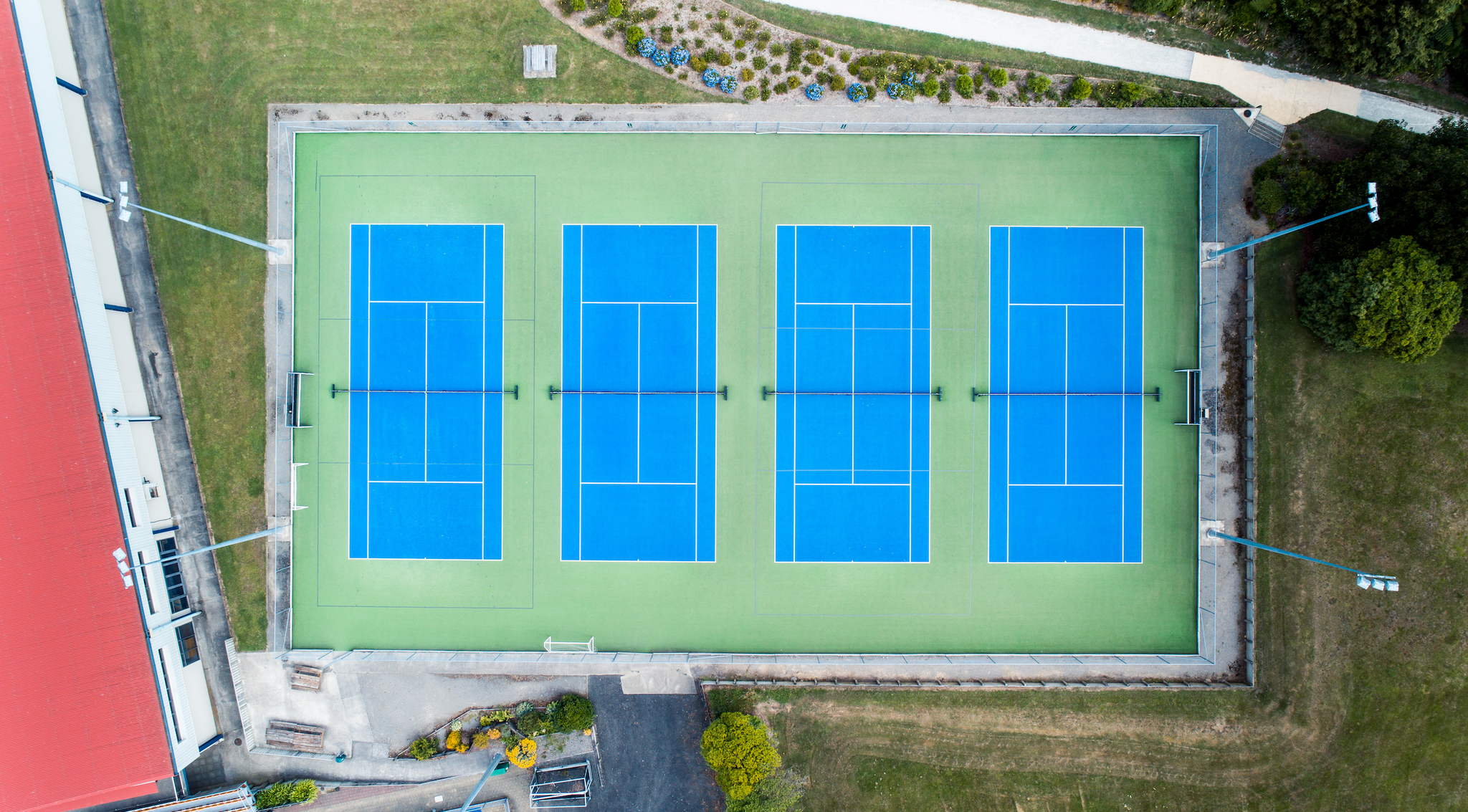 Drone image of bright blue and green tennis courts.