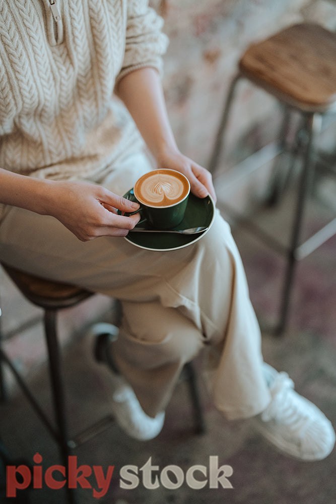 Woman sitting in the Cafe and holding a cup of coffee.