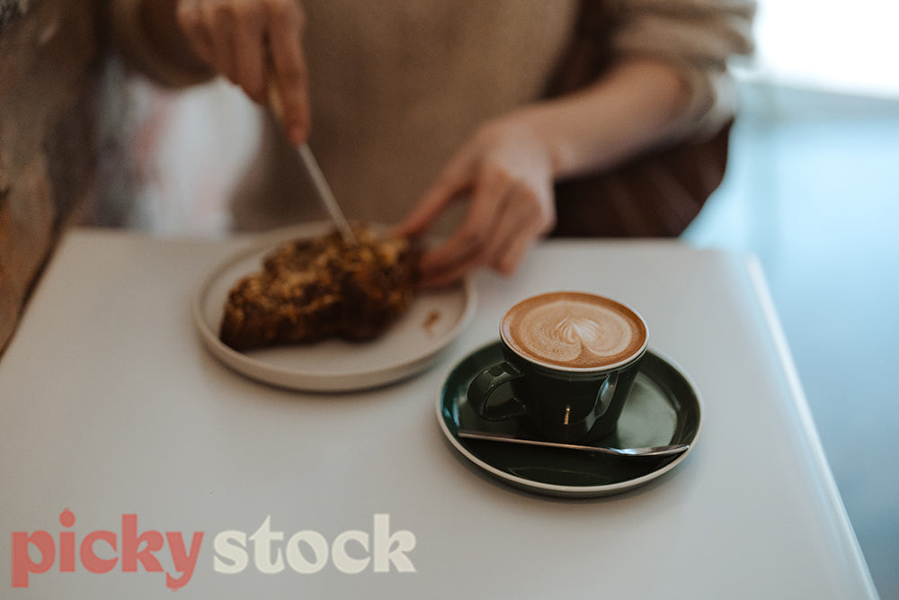 Woman sitting in the Cafe and holding a cup of coffee.