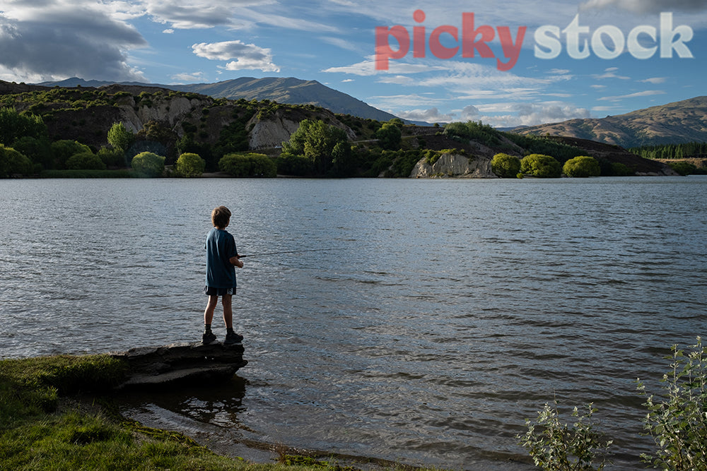 Boy fishing in lake in Central Otago