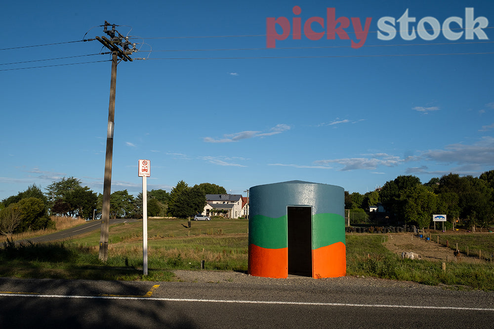 Colourful bus stop against rural environment