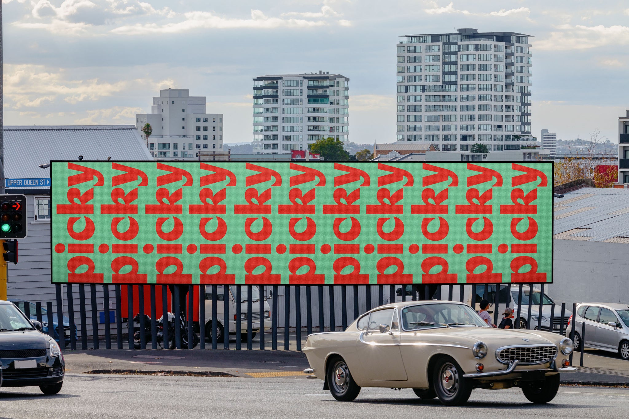 Mockup image of a long landscape billboard in Auckland city. With a beige vintage car in front of it.