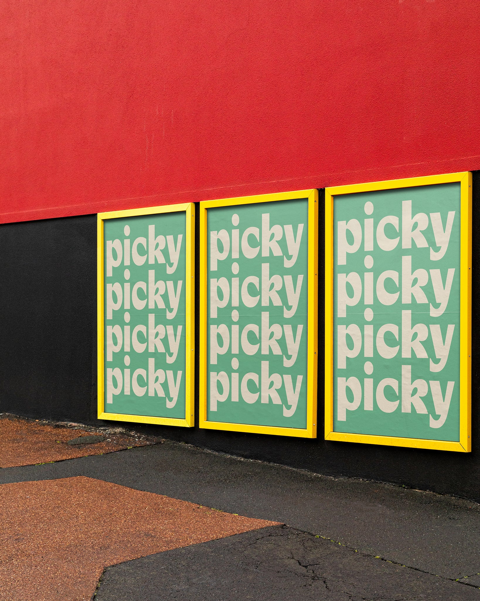 Three street posters in yellow frame, against red wall.