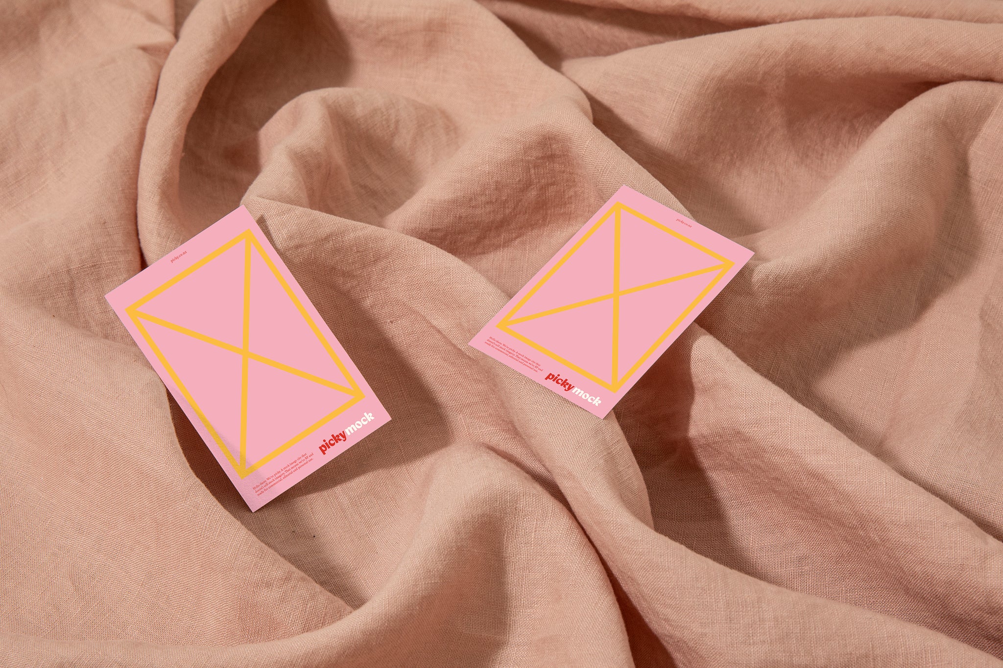 Business cards sitting on top of a pink cloth. Placed in a relaxed way. 