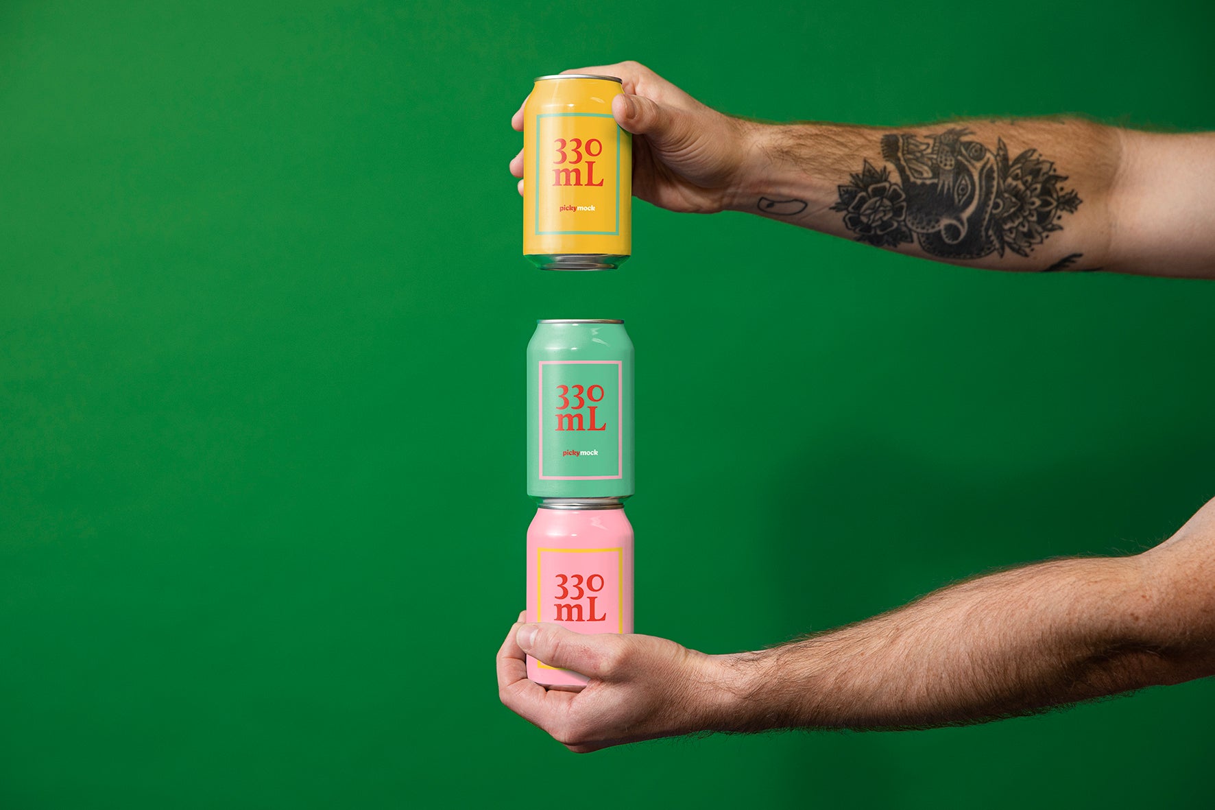 Tattooed arms hold out three cans stacked. Against a green studio backdrop.