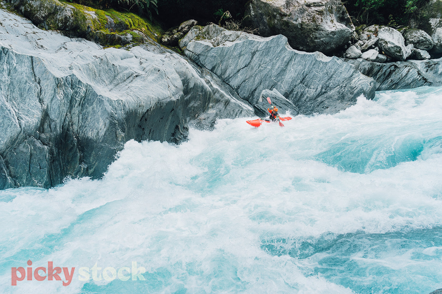Whitewater kayaker in big rapid on turquoise river