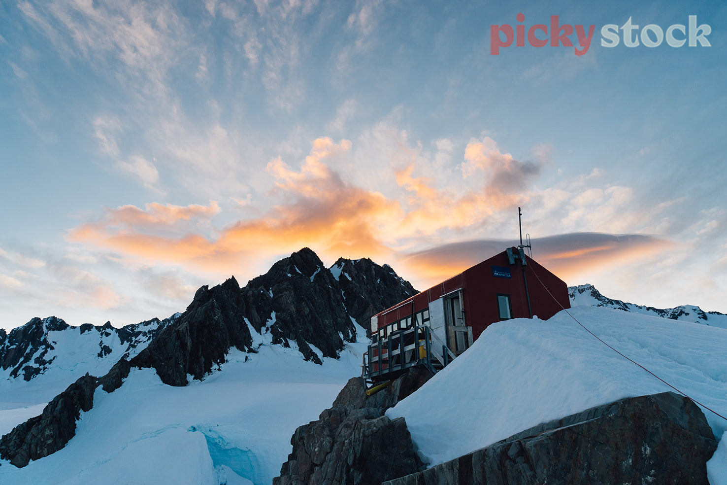 Pioneer Hut under colourful sunset clouds on the Fox Neve