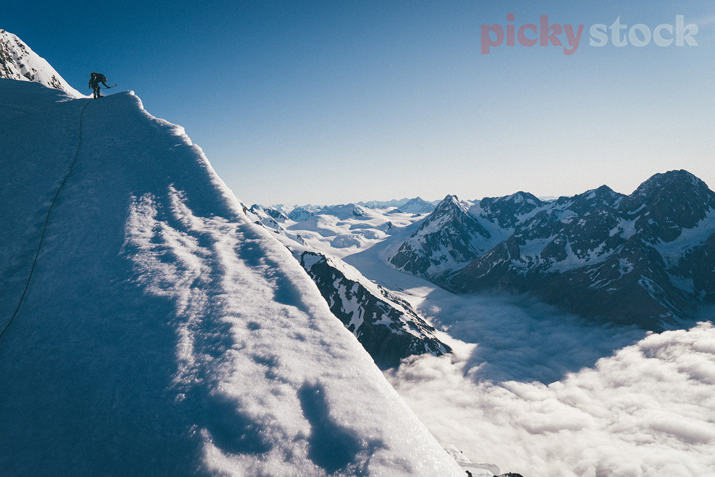 A mountain climber builds an anchor along an icy ridge