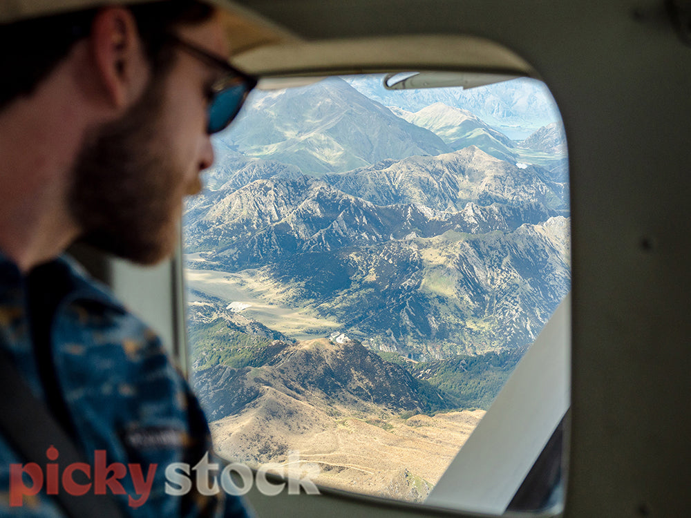 Man looks at scenic view from airplane window