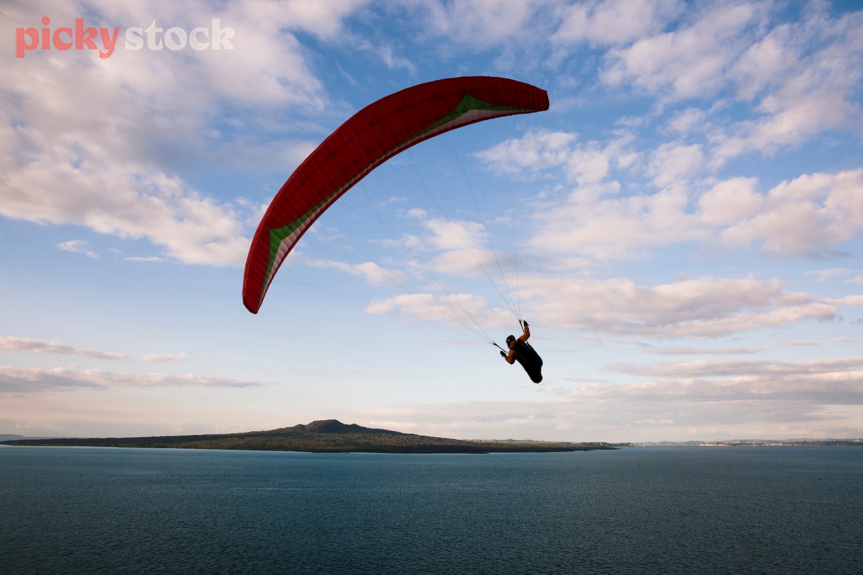 Paraglider over Rangitoto on a bright blue day.