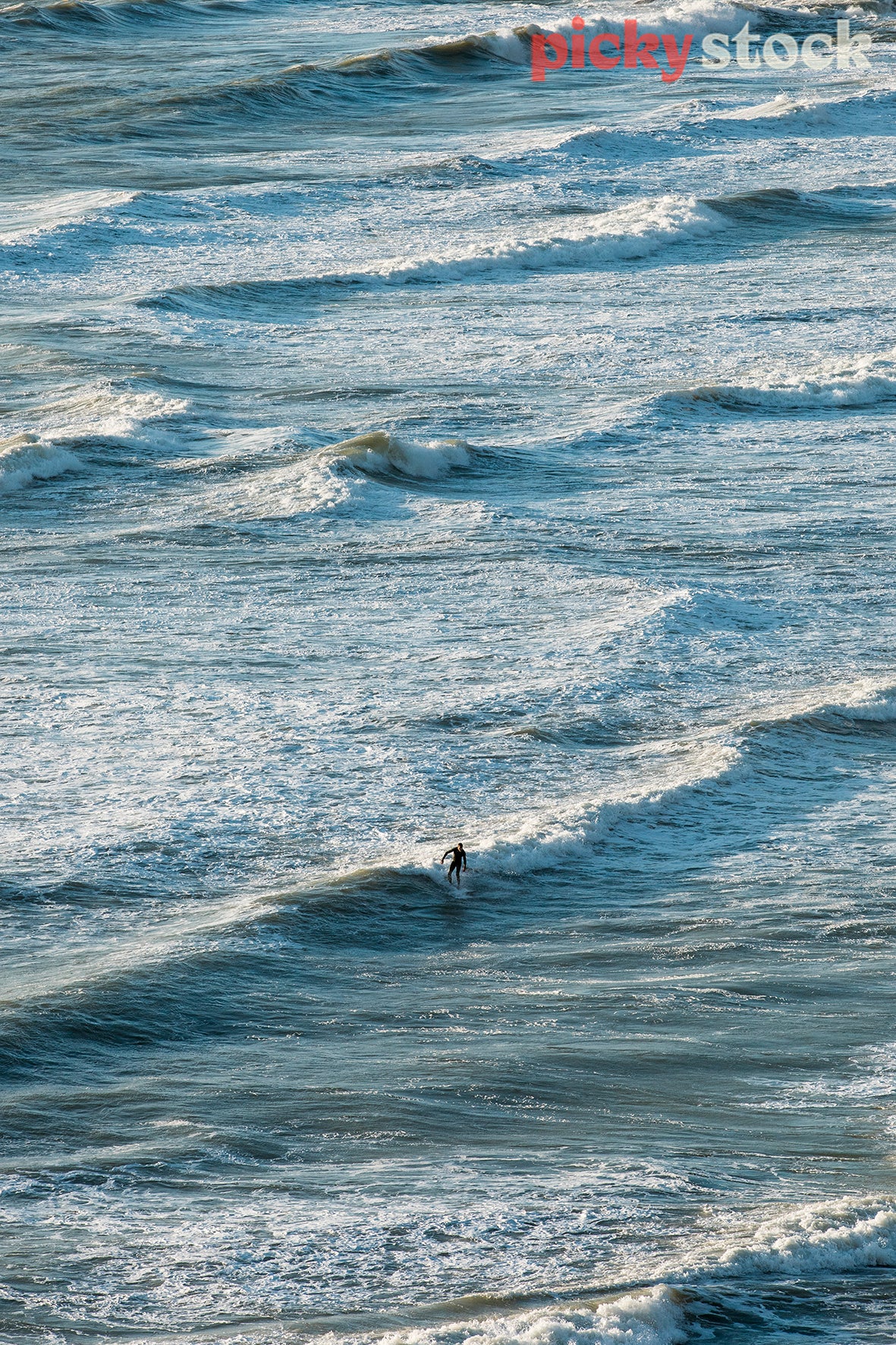 Lone surfer on the waves at O'Niels bay, Te Henga, West Auckland. 
