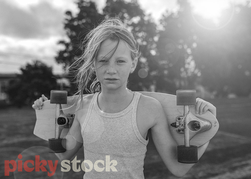 Black and white portrait of young girl holding a skateboard