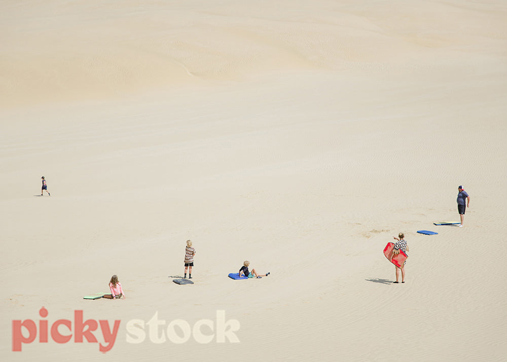 Family with bodyboards at the sand dunes