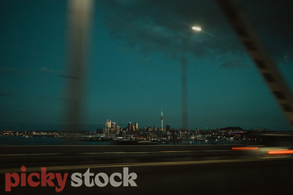 Semi blurred cityscape show from a moving car as Auckland city heads into evening. 
