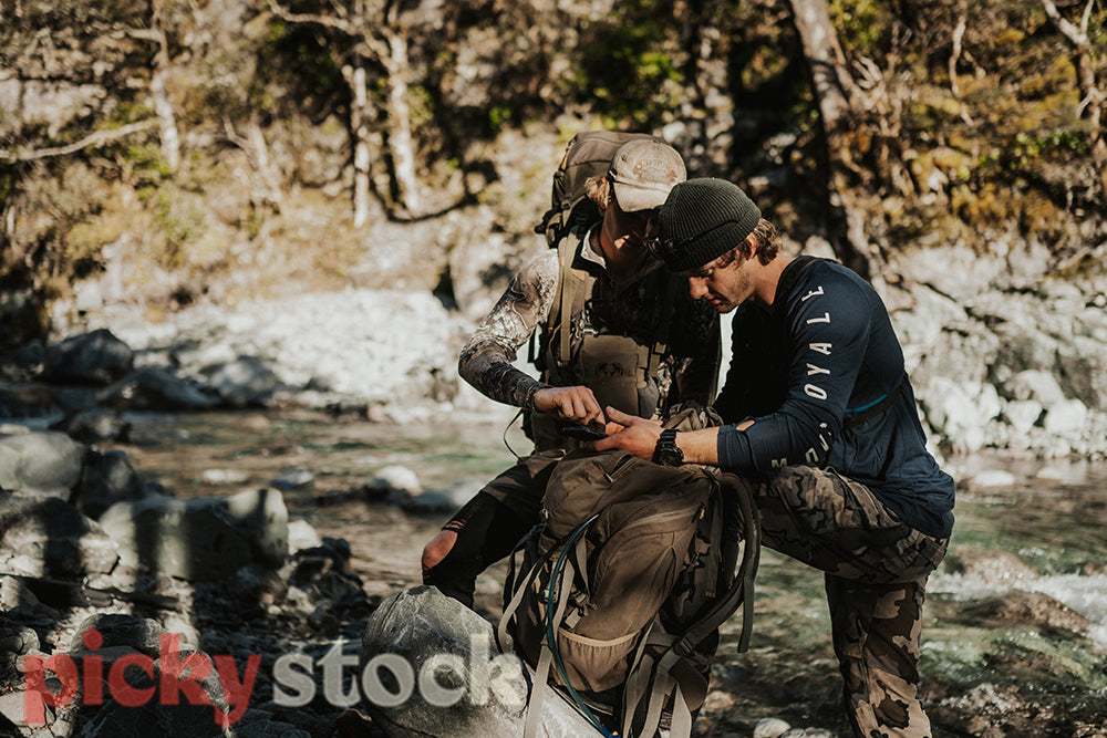 Two hunters navigating through a river gorge