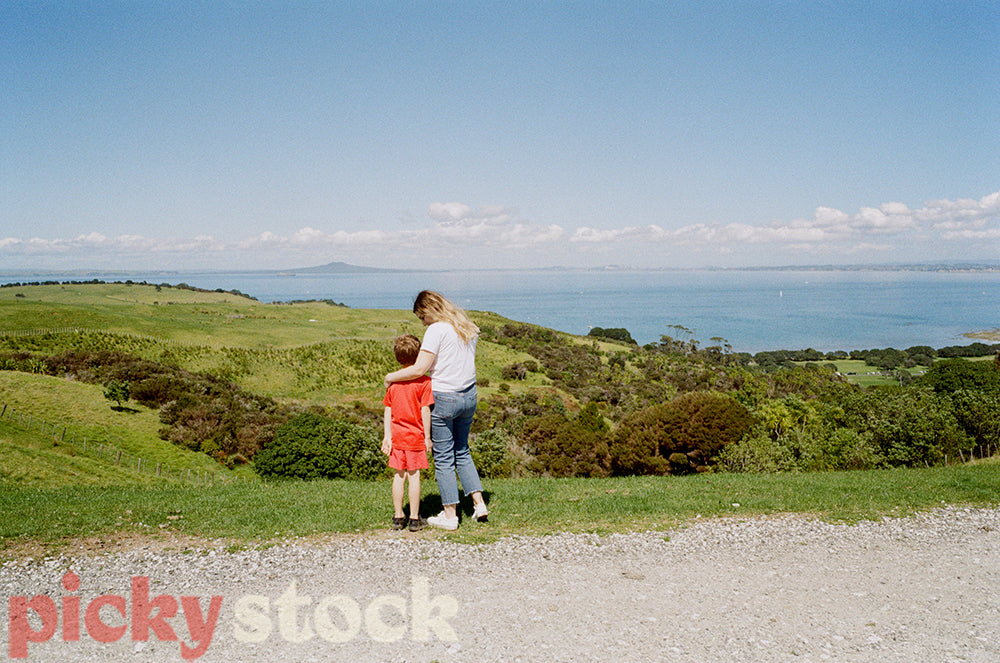 Mum and son look out over the ocean while on a trail walk.