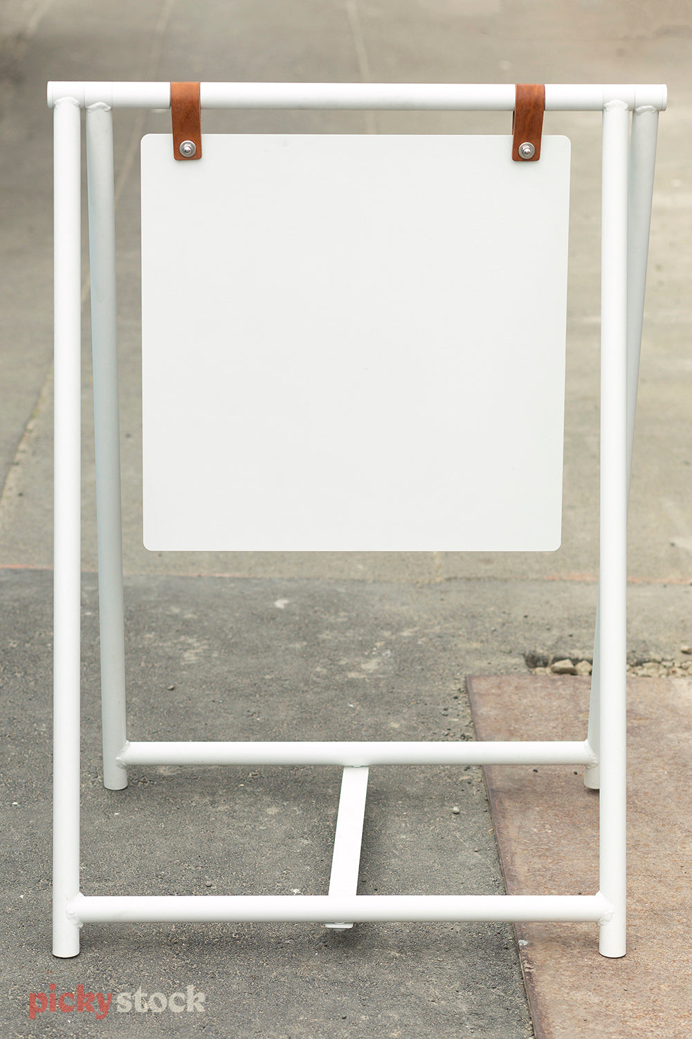 Modern white blank signboard sits outside on pavement.