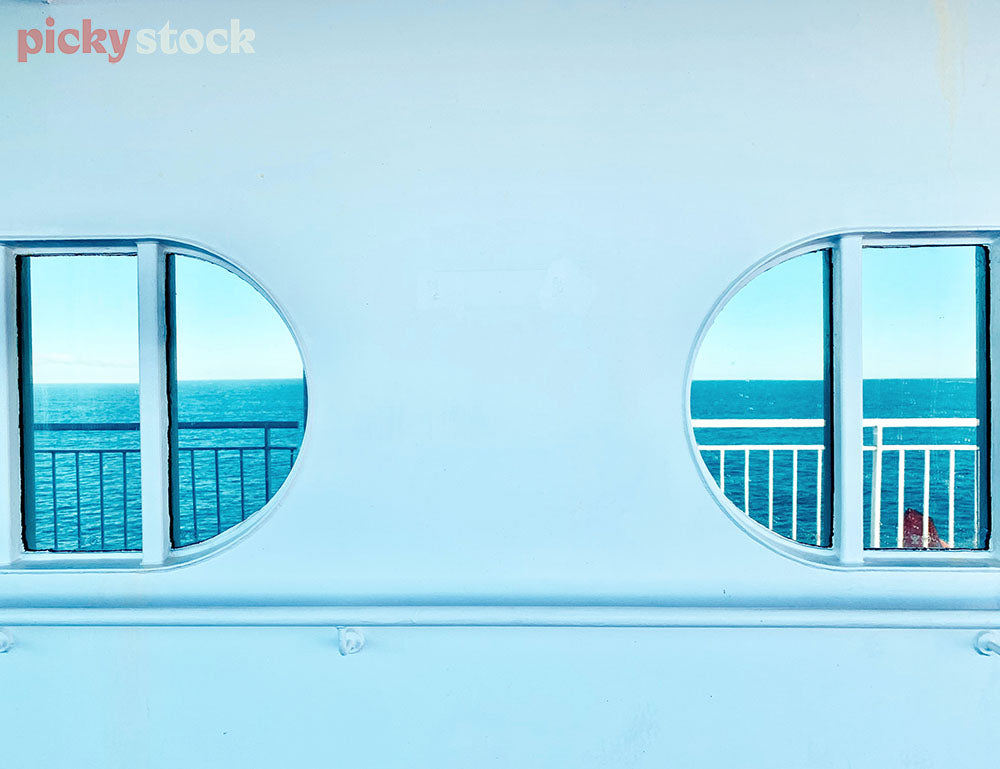 Symmetrical ferry windows reflecting out to sea.  