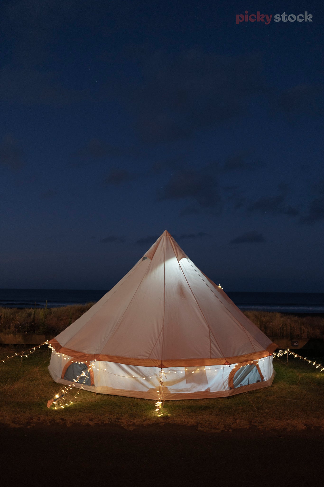 Large glamping tent tent glows and twinkles at Oakura. Fairy lights and outdoor lights surrouding it. 