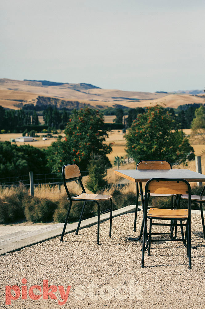 Outdoor wooden chairs and table to wairarapa wedding venue, overlooking the hills. 