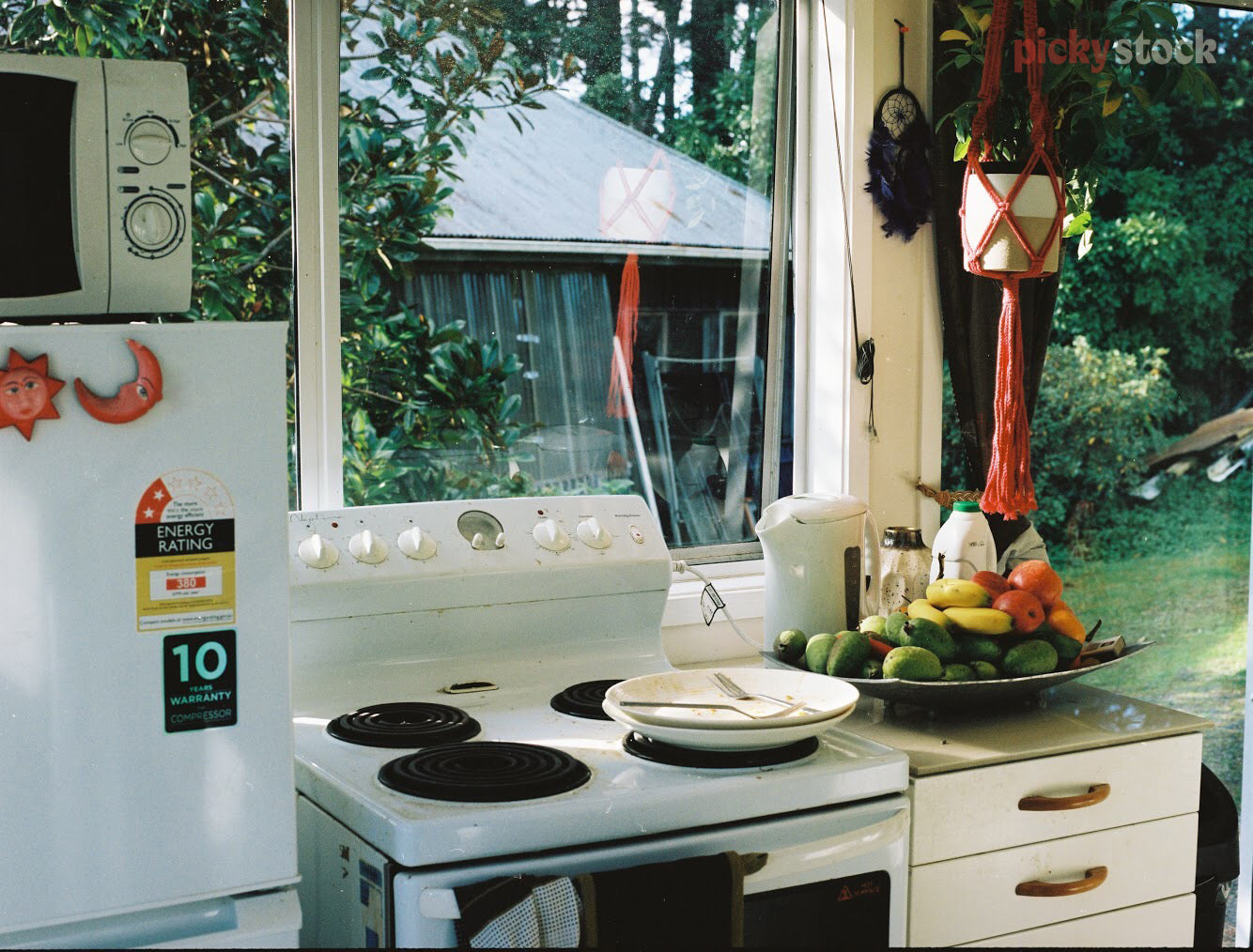 A modest home kitchen, including oven and bench top. 