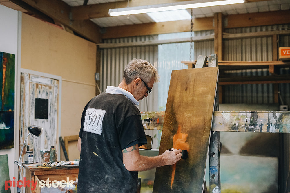 Man painting abstract art on canvas in his art studio
