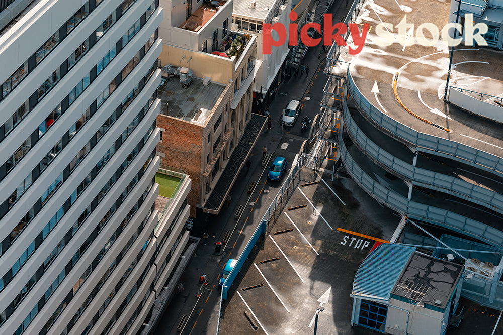 Aerial viewpoint of city street roads, high rises and carpark building. 