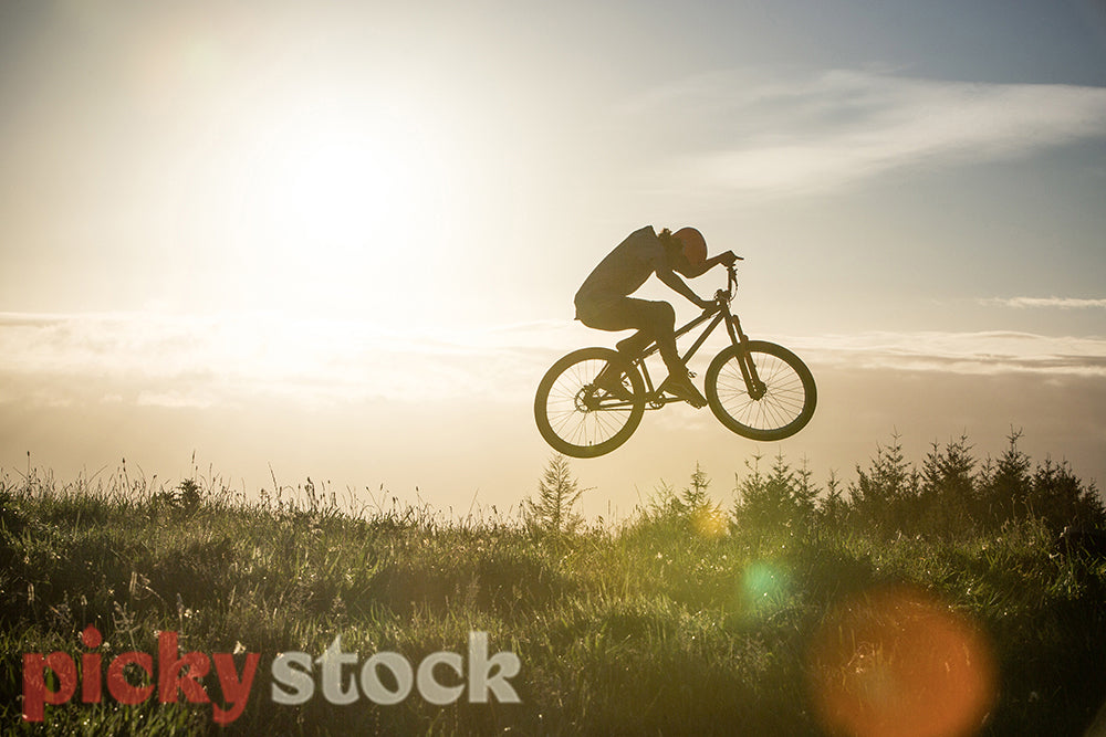 Sun rise with jumping mountain biker
