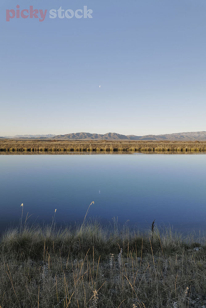 Stunning blue day in Twizel, the blue sky reflected onto the still water.