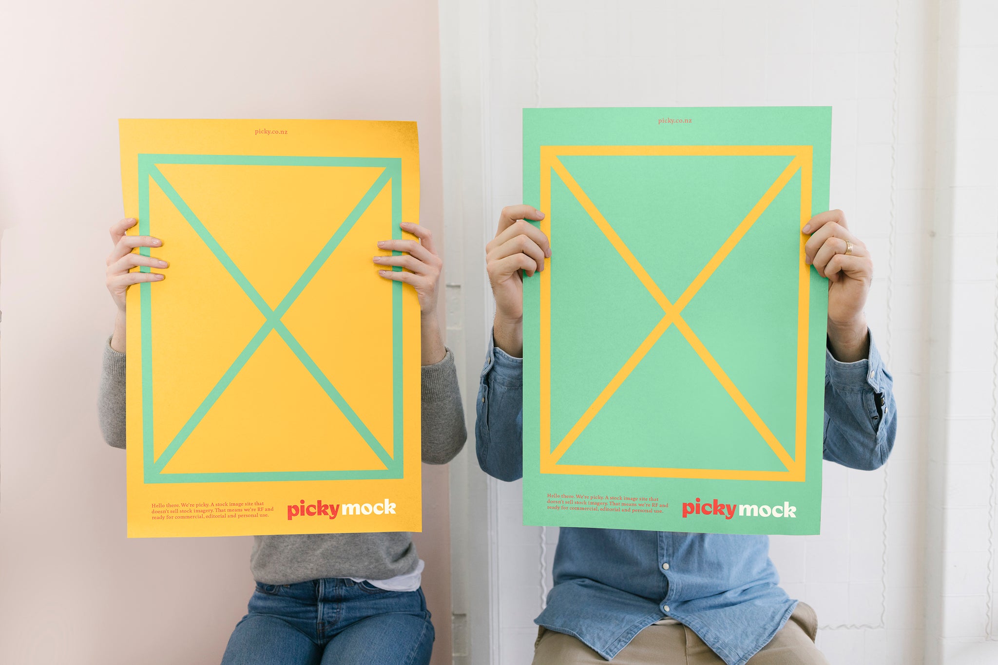 Landscape of two people obscured by holding up mock advertisements in green and yellow featuring small red picky logo.